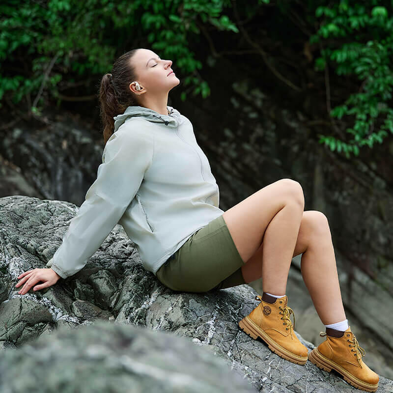 A Lady Rest with AirFit Open-ear earbuds while climbing