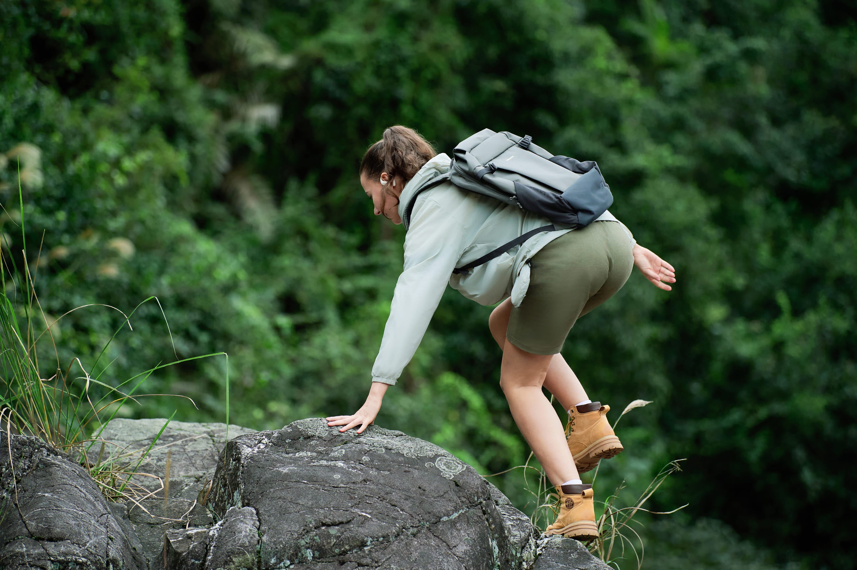 A lady wearing Airfit  headphones is climbing