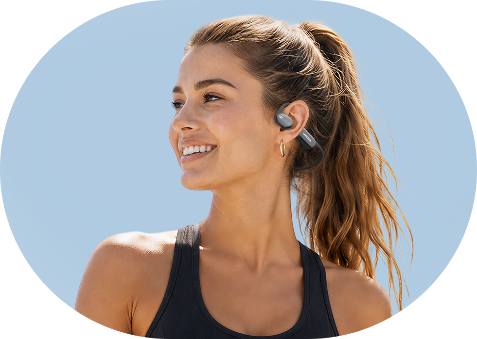Man running outdoors while wearing AirWave Pro2 open-ear sports headphones in Storm Gray