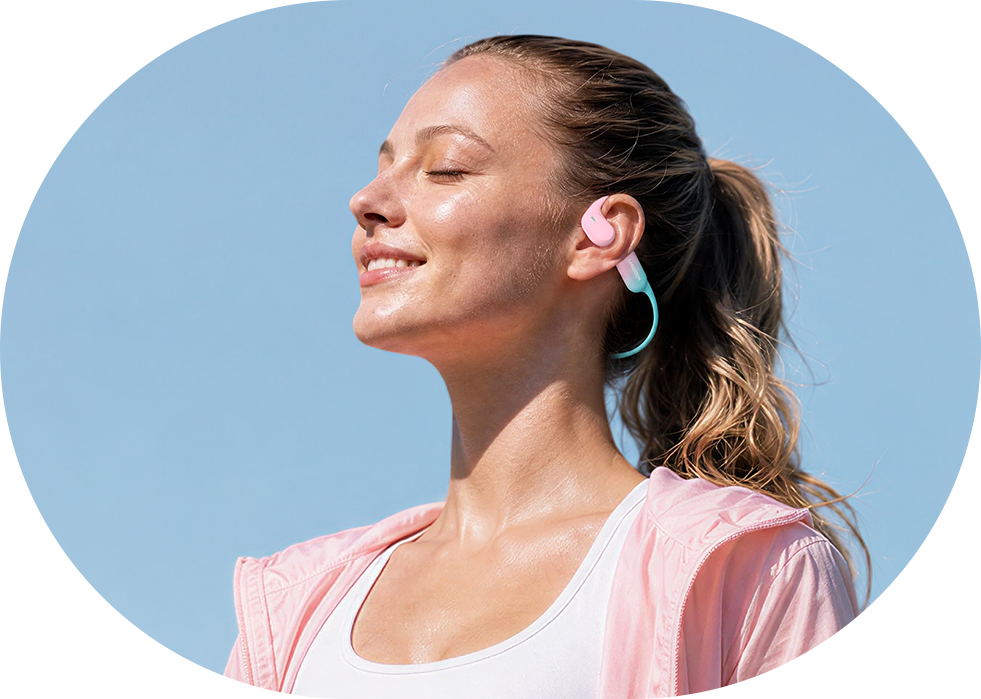 Woman walking outdoors while wearing AirWave Pro2 open-ear sports headphones in Coral Pink